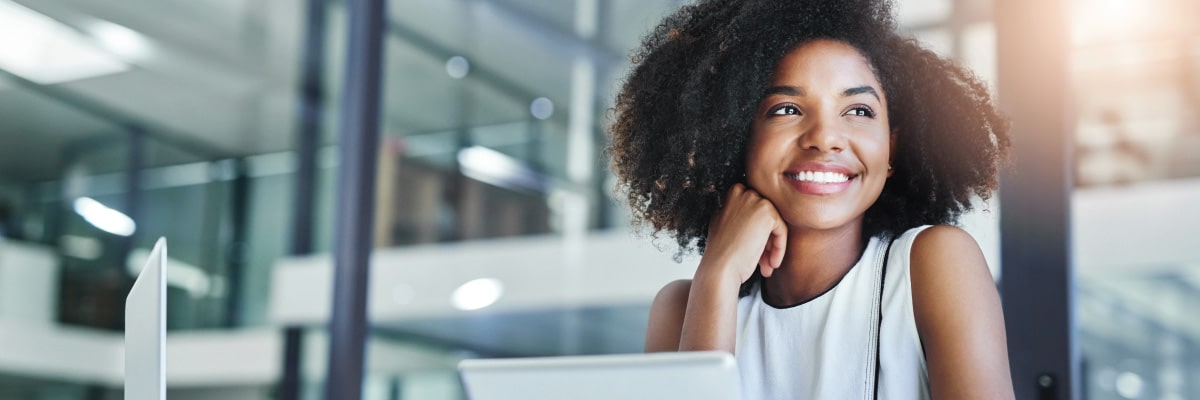 Smiling Woman Resting Hand on Face While at Computer