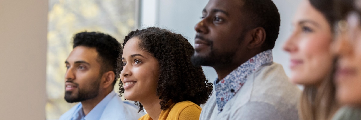 People Sitting While Watching a Presentation and Smiling