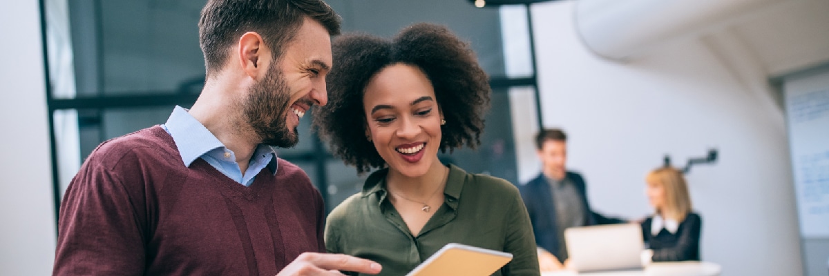 Man Talking to Woman While Pointing at Tablet