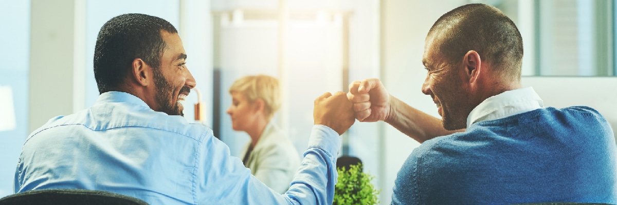 Two Men Smiling and Fist-bumping