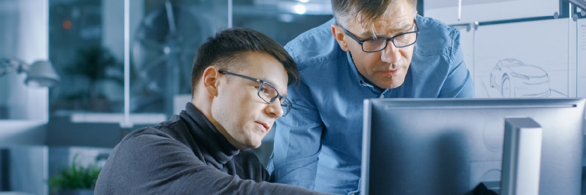 Two Men looking at a Computer Screen While Having a Discussion