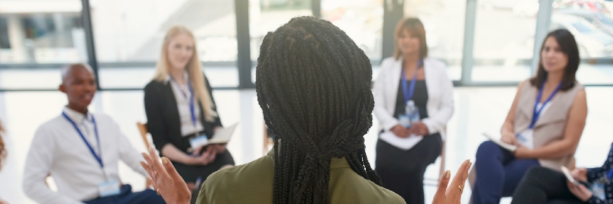 People Sitting in a Circle Listening to Someone Talk