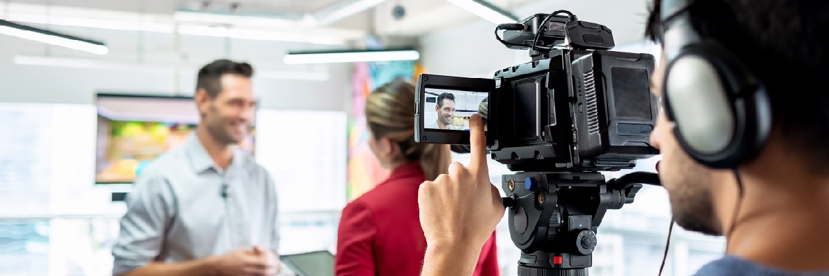 Man Pointing at Video Camera Screen While Recording an Interview