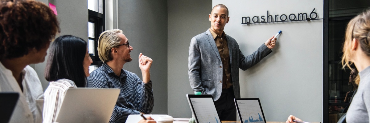 Man Pointing to Business Logo in Conference Room