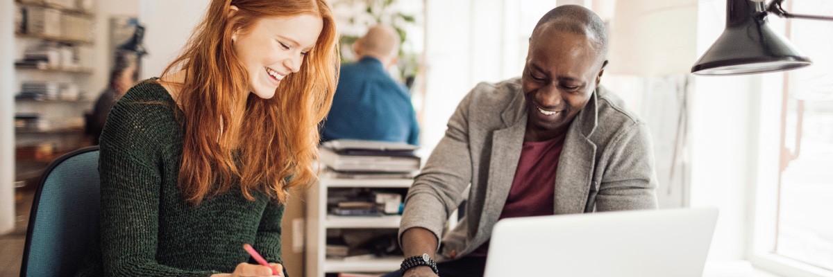 Man and Woman in Front of Laptop Happily Working