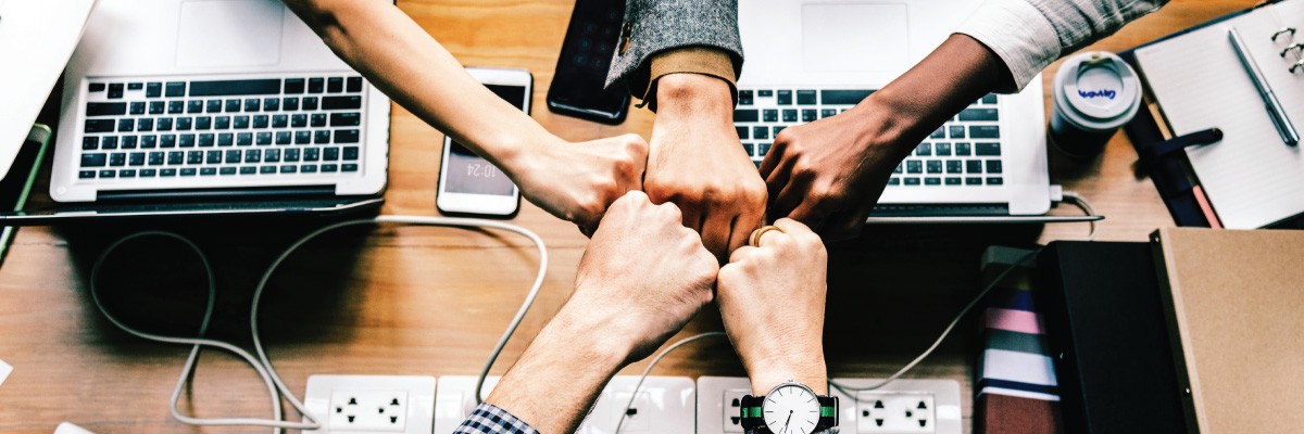 Group of Fists Together Over a Table
