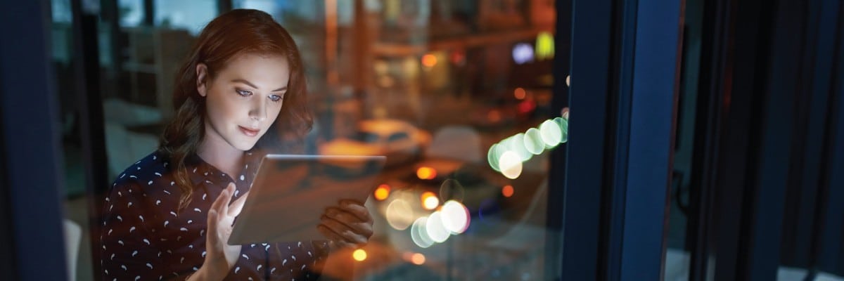 Woman in Window Working on an iPad