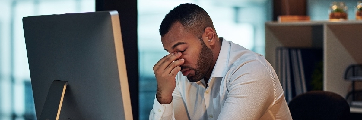 Man Looking Distressed and Pinching the Bridge Between his Nose