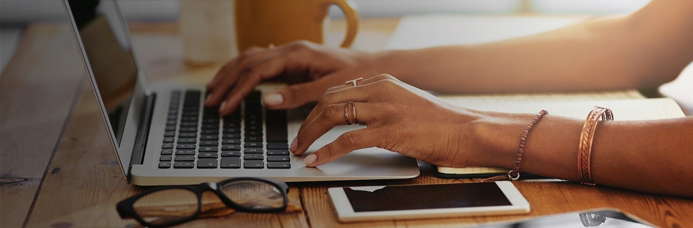 Hands Typing at Laptop with Coffee Cup