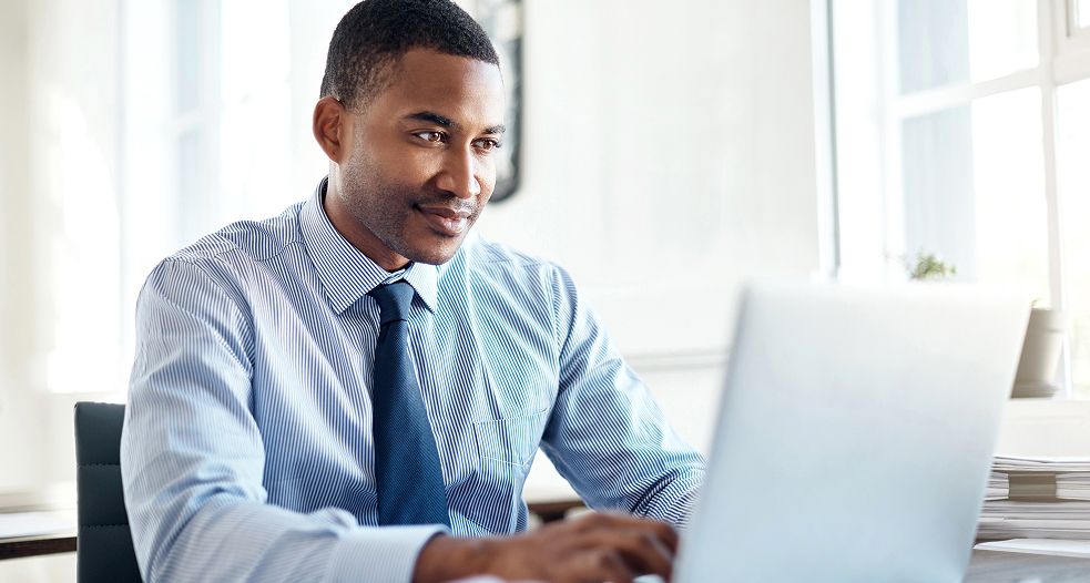 Image shows a professional man working on his laptop.