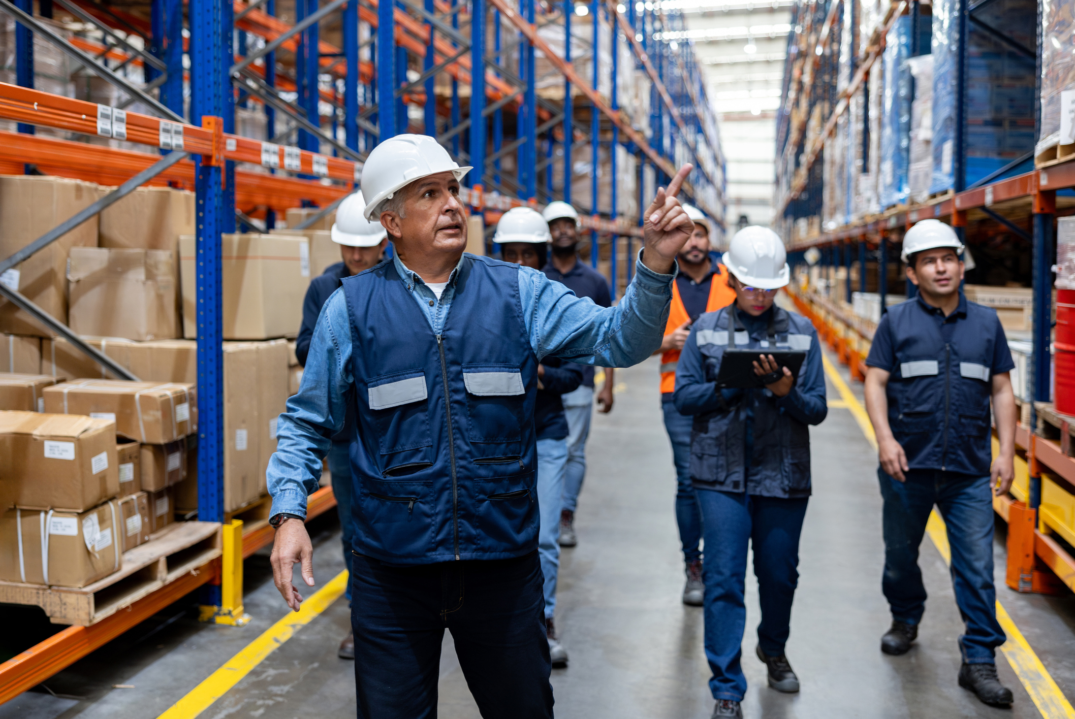 Warehouse manager leading new employees through facility during structured onboarding walkthrough